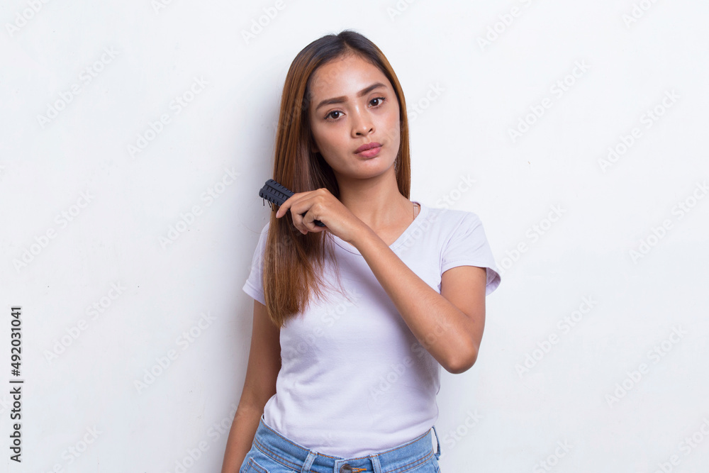 young beautiful asian woman combing long hair with a comb isolated on white background
young beautiful asian woman combing long hair with a comb isolated on white background