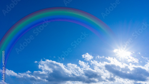 Bright blue sky with rainbow and sunshine_wide_05