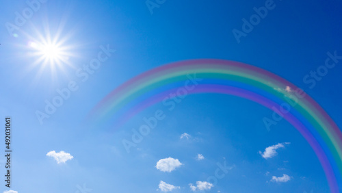 Bright blue sky with rainbow and sunshine_wide_10