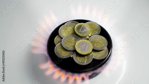 Concept of gas crisis. Euro coins is burning on a kitchen stove burner. European cash money. High prices of natural resources. Fire flame. Utility debt. Energy war. Saving home budget. Finance photo