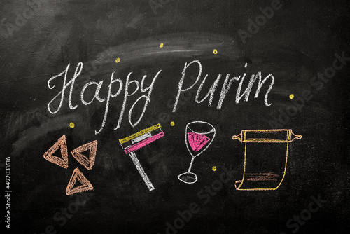 chalk lettering on the blackboard Happy Purim.