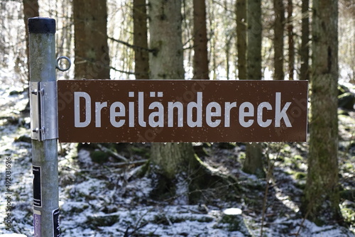 Sign 'Dreiländereck' (border triangle Hessia, Rhineland-Palatinate, North Rhine-Westphalia) with water drops, winter forest (horizontal), Rabenscheid, Hessia, Germany