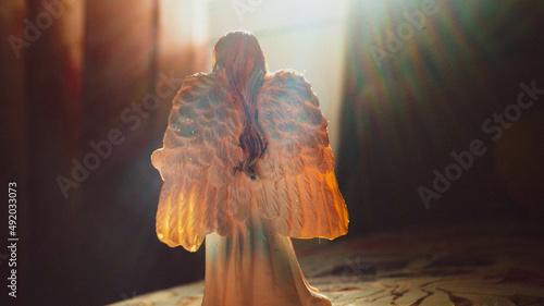 фигура ангела на фоне яркого солнечного света