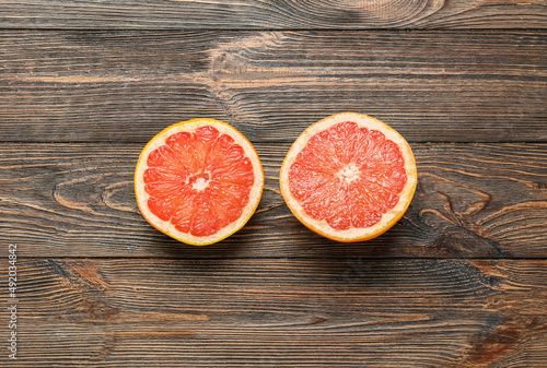 Tasty cut grapefruit on wooden background