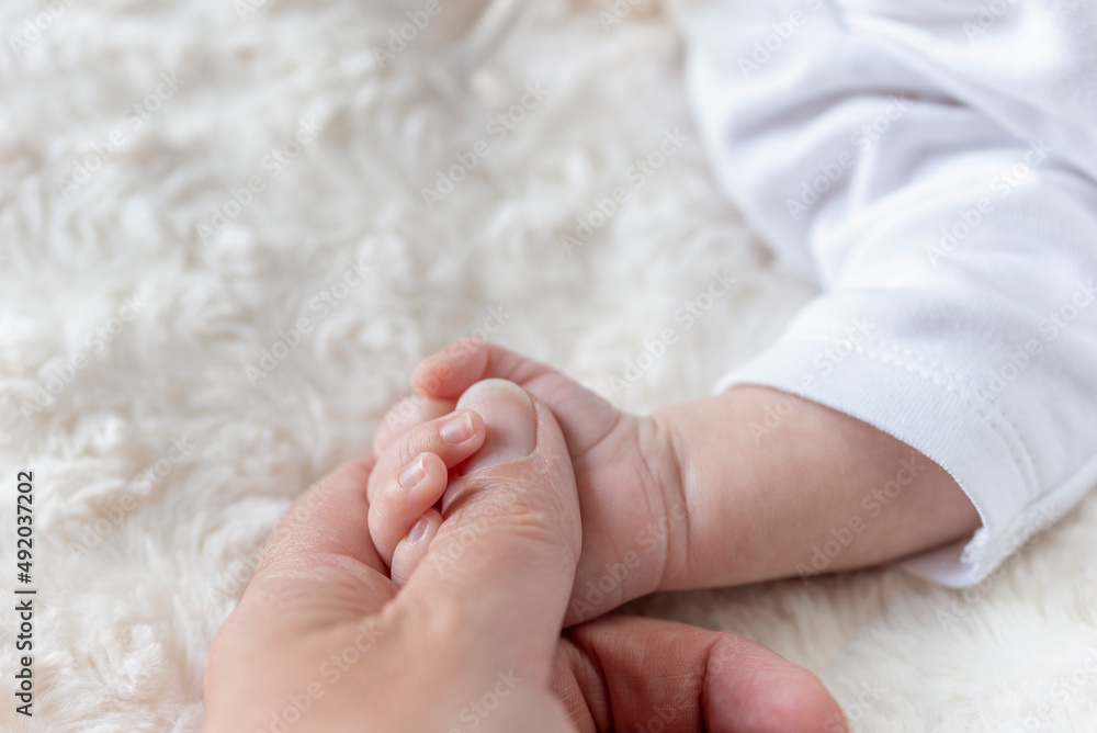 new born baby hand holding mom finger on bed new born baby hand holding mom finger on bed