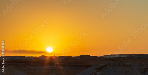 Sun going down and orange sky, wind eroded rock formations, Egyptian White Desert. Western Desert, Egypt