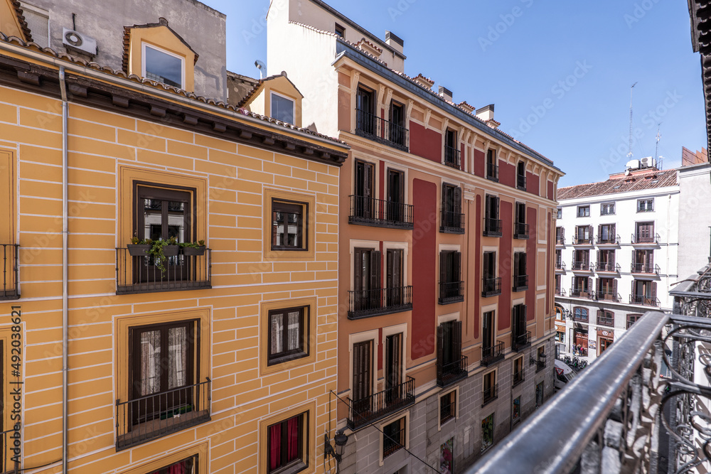 Facades of old houses in the center of Madrid seen from the support of a balcony railing