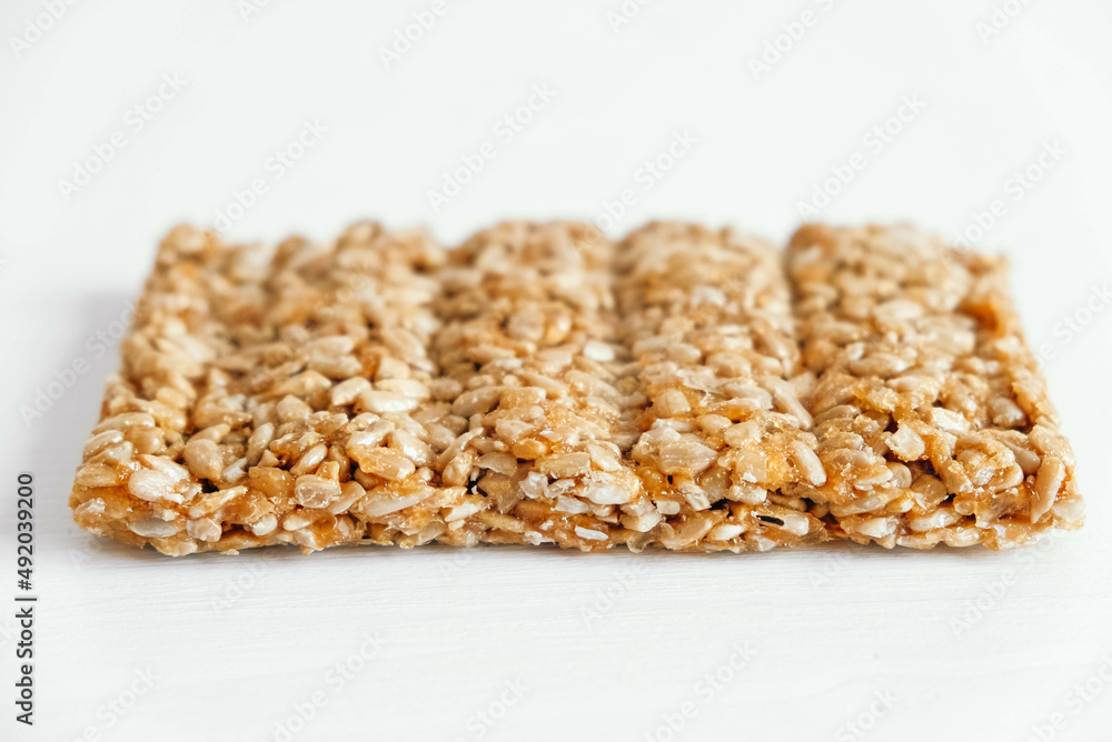 Delicious sweet kozinaki pieces on white wooden table Delicious sweet kozinaki pieces on white wooden table