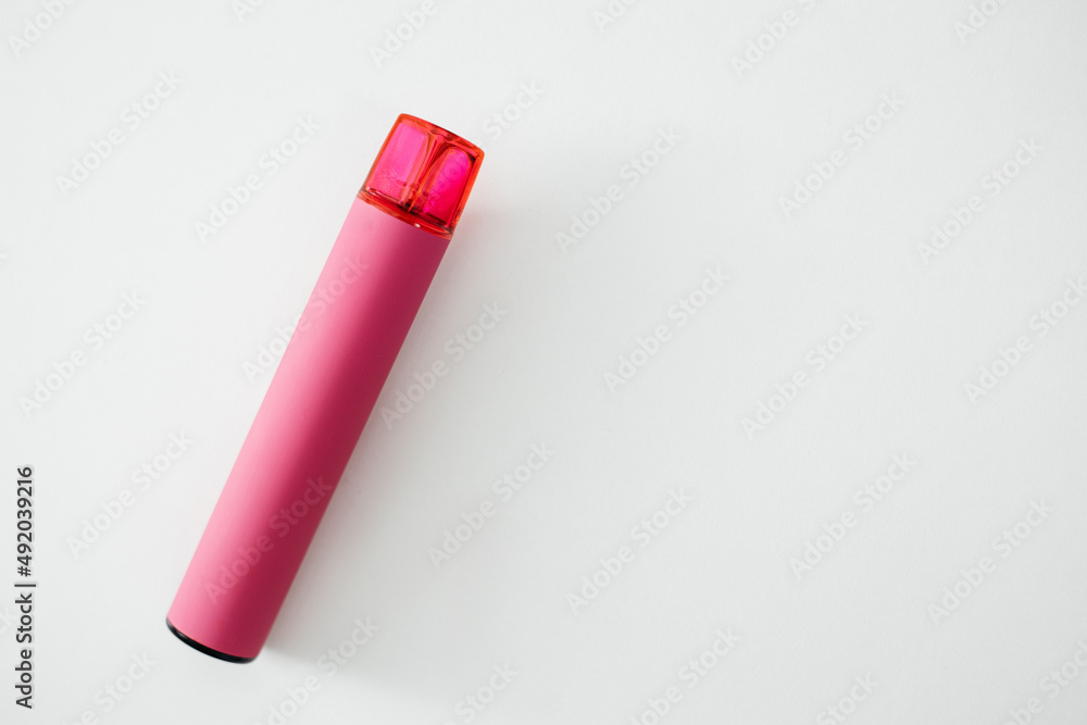 Pink disposable electronic cigarette on a white table Pink disposable electronic cigarette on a white table