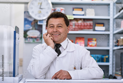 Happily waiting for the next customer. Portrait of a male pharmacist in a pharmacy.