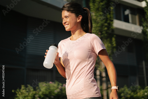 Fit athlete woman in sportswear outdoors. Young woman jogging outside..