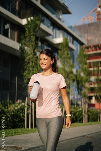 Fit athlete woman in sportswear outdoors. Young woman jogging outside..