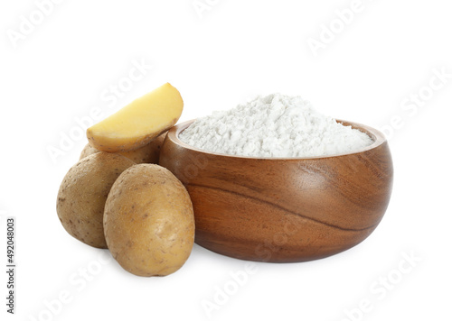 Wooden bowl with starch and fresh potatoes on white background