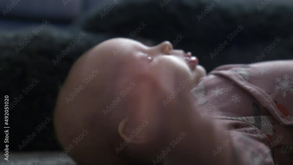 Baby girl lying and turning on floor, motor skill natural development Baby girl lying and turning on floor, motor skill natural development