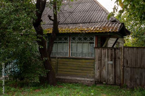 Forgotten old building in little suburb. Early fall trees of green  colors  © Oksana