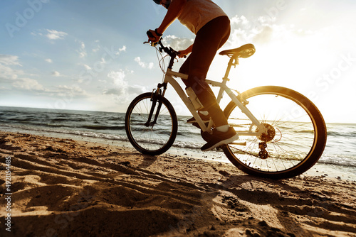 Fototapeta Naklejka Na Ścianę i Meble -  image of a man on a bicycle ride on a sandy beach.