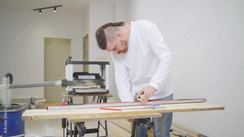 carpenter makes measurements and draws on wood carpenter makes measurements and draws on wood