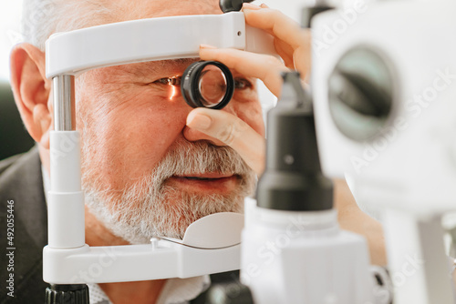 Картината върху платно examination of elderly man with slit lamp. medical equipment