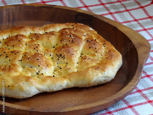 Homemade Turkish Ramadan pita bread, called "Ramazan pidesi" in Turkish, is a traditional flat bread topped with sesame and Nigella sativa seeds. 