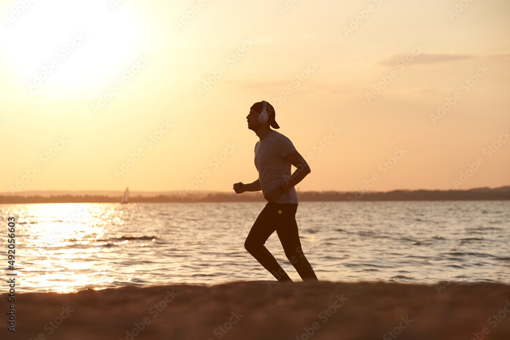 young man on an evening jog along the lake shore. young man on an evening jog along the lake shore.