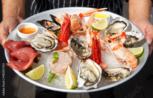 delizioso piatto di Pesce e frutti di mare crudi serviti su un piatto bianco photo