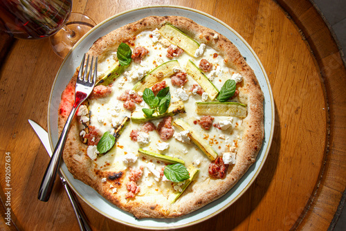 pizza tonda  farcita con noci e e formaggio servita su un piatto in un tavolo di una pizzeria  photo