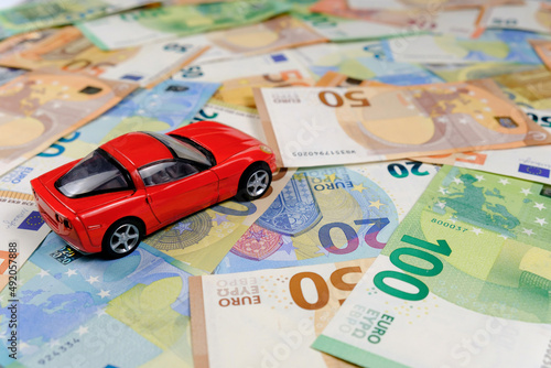 Small toy car and money. Loan and finance concepts