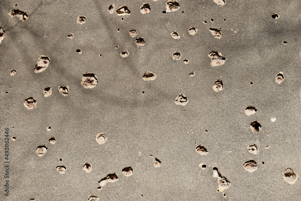 Bullet holes on the facade of a residential building. Stop the war. Armed conflicts. Defund the armies. No to war.
