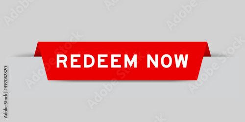 Red color inserted label with word redeem now on gray background
