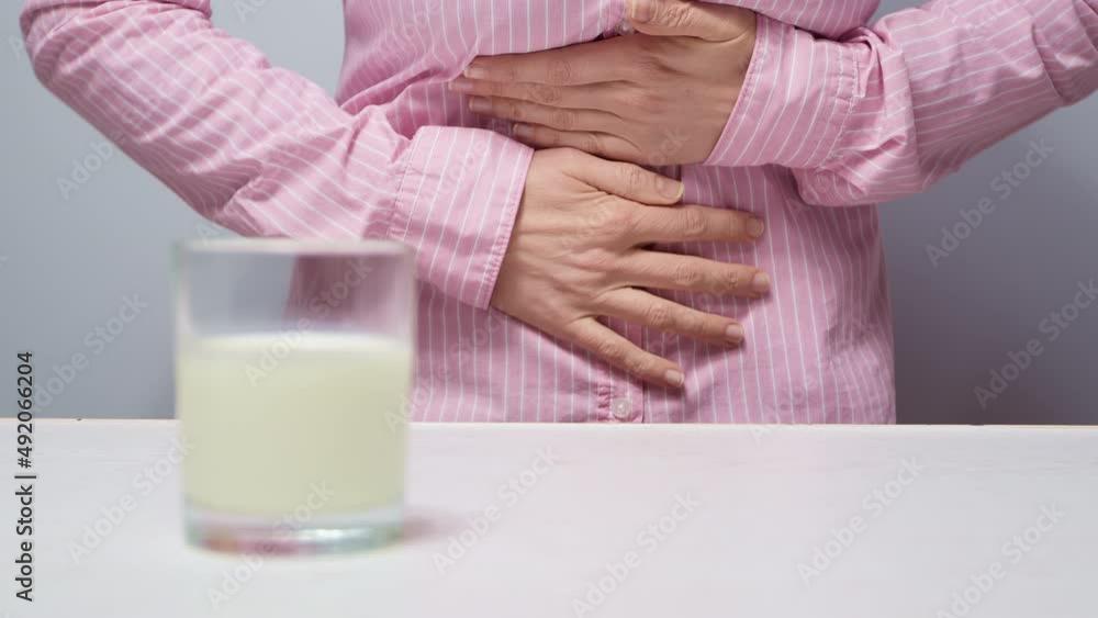 Lactose intolerance concept. Pain in abdomen after drinking milk. Stock