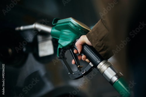 Close-up of woman pouring fuel in gas tank of her car. photo