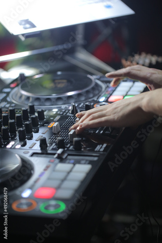 Close up of DJ hands controlling a music table in a night club