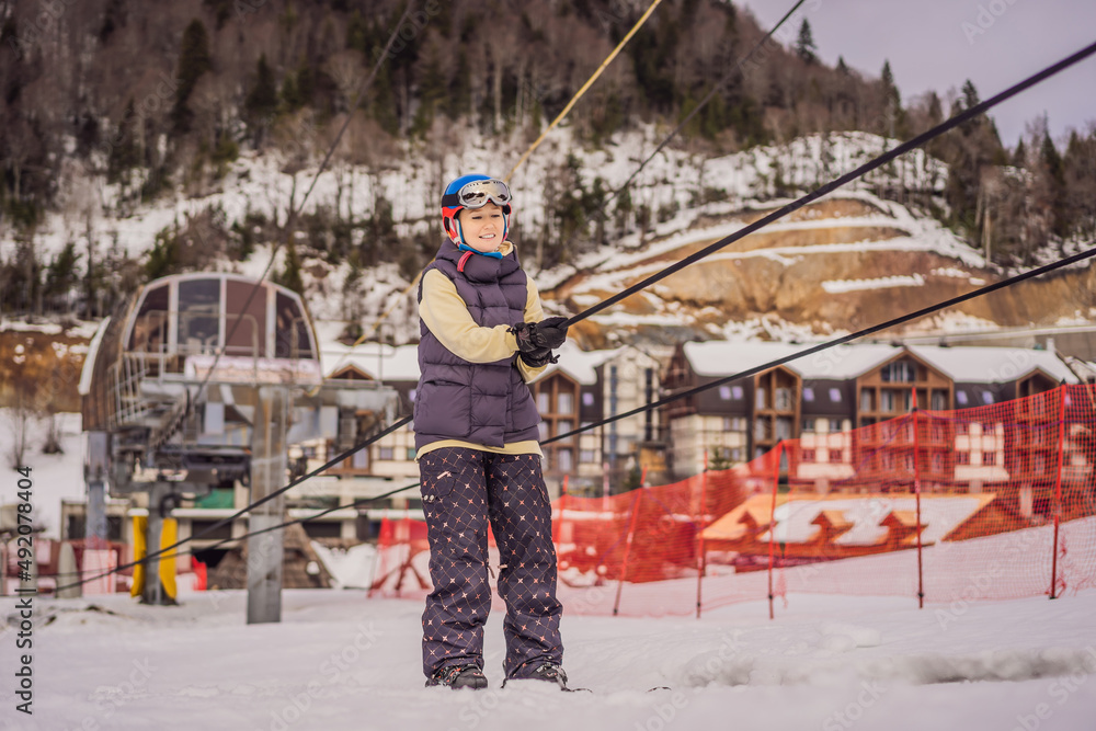 Woman skier climbs a mountain on a ski lift for beginners Woman skier climbs a mountain on a ski lift for beginners