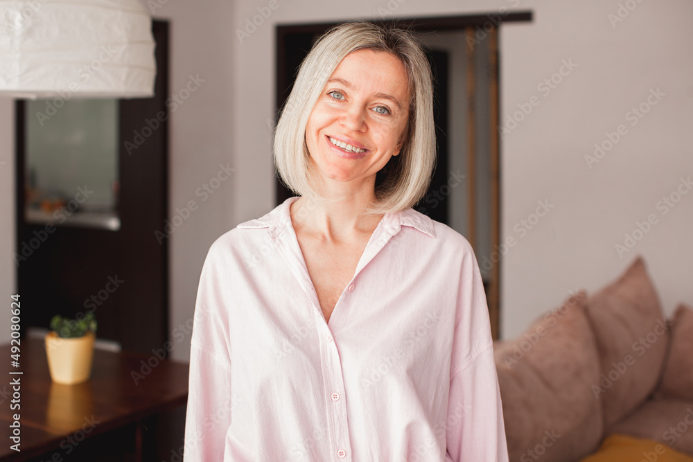 Smiling middle aged mature woman looking at camera at home Smiling middle aged mature woman looking at camera at home