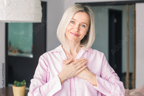 happy adult female volunteer holding folded hands on chest