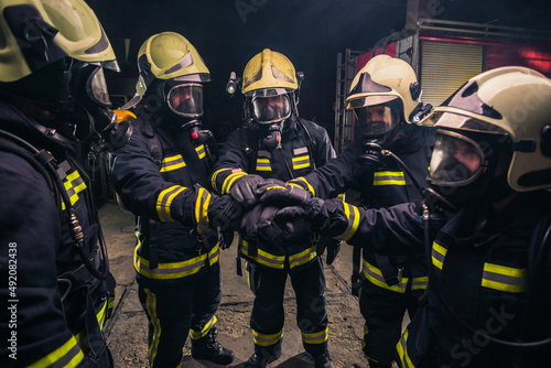 Photo Team of firemen in uniform with gas masks inside the fire department