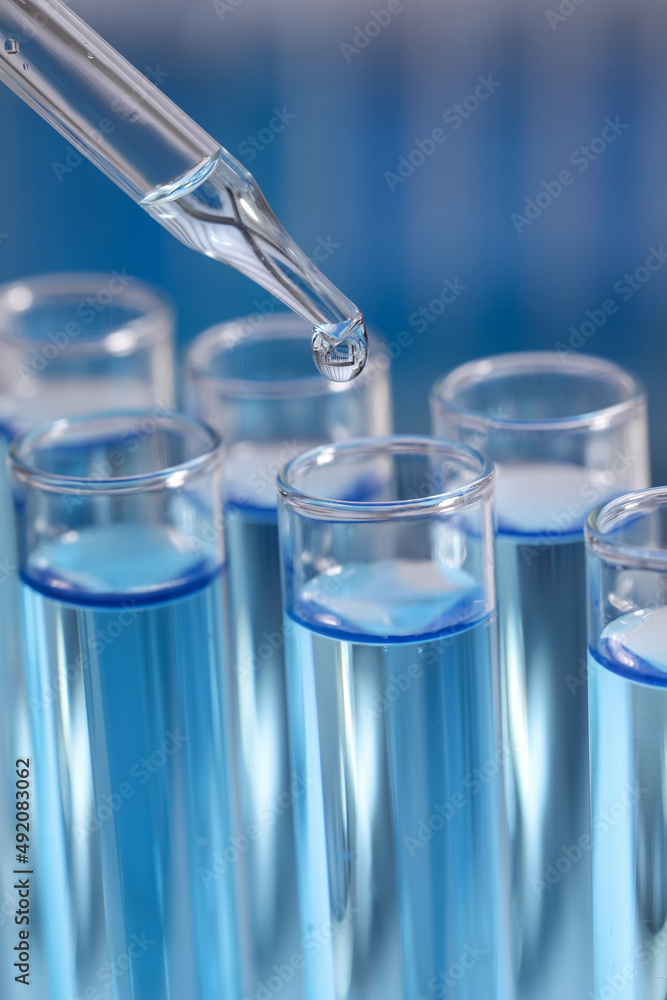 Dripping reagent into test tube on blurred background, closeup. Laboratory analysis Dripping reagent into test tube on blurred background, closeup. Laboratory analysis