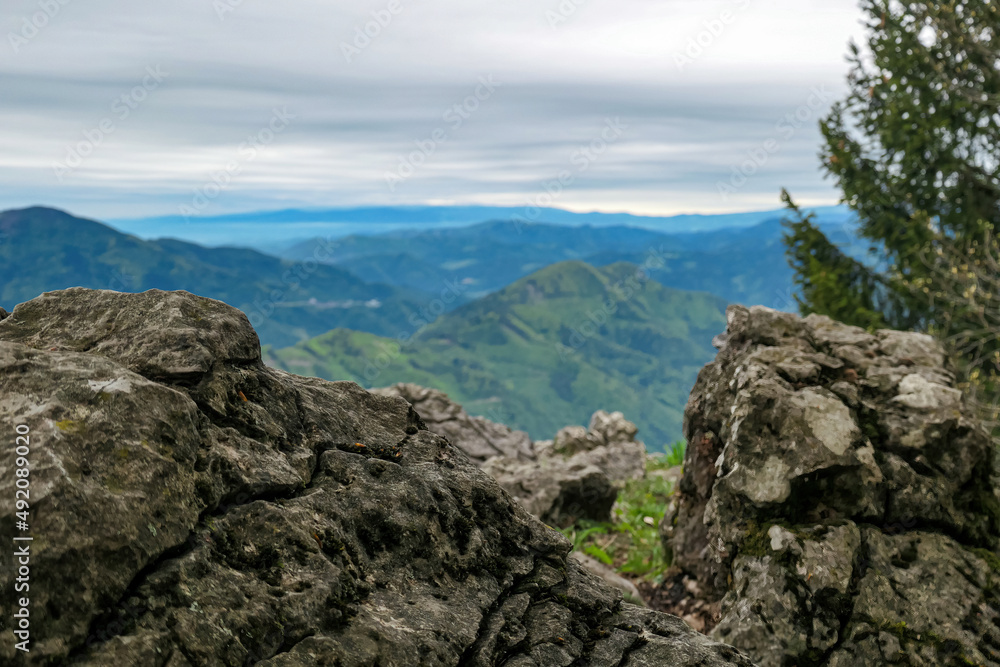 Close up view on rocks with scenic view from summit of mount Roethelstein near Mixnitz in Styria, Austria. Landscape of green alpine meadow of Grazer Bergland in Styria, Austria. Lake