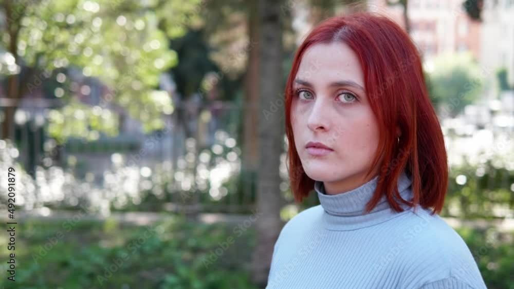 thoughtful young woman looks at the camera with frowning look thoughtful young woman looks at the camera with frowning look