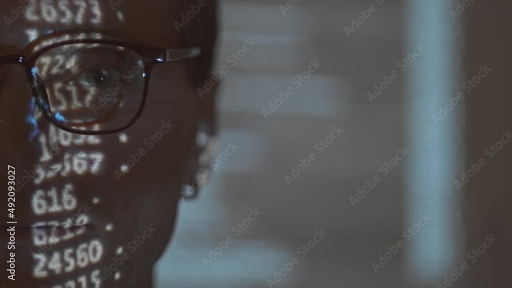 Half face closeup portrait of Caucasian man in eyeglasses looking at camera with program code projected in his face Half face closeup portrait of Caucasian man in eyeglasses looking at camera with program code projected in his face