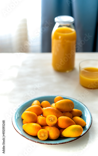 Kumquats on blue plate with citrus juice