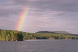 Rainbow over Iovskoye reservoir on sunny summer day. Murmansk Oblast, Russia.