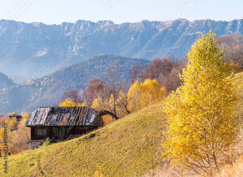 Rustic landscape with an abandoned old wooden house or shelter in the Carpathain Mountains, Romania. Autumn landscape.