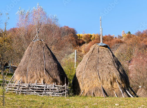 Rustic rural landscape in a romanan village with a haystack on the field. photo