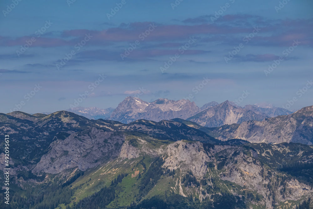 Panoramic view from Messnerin on Hochtor and alpine mountain chains in Styria, Austria, Hochschwab region. Hills overgrown with bushes, higher parts rocky. Summer day. Hiking in Alps, Tragoess Panoramic view from Messnerin on Hochtor and alpine mountain chains in Styria, Austria, Hochschwab region. Hills overgrown with bushes, higher parts rocky. Summer day. Hiking in Alps, Tragoess