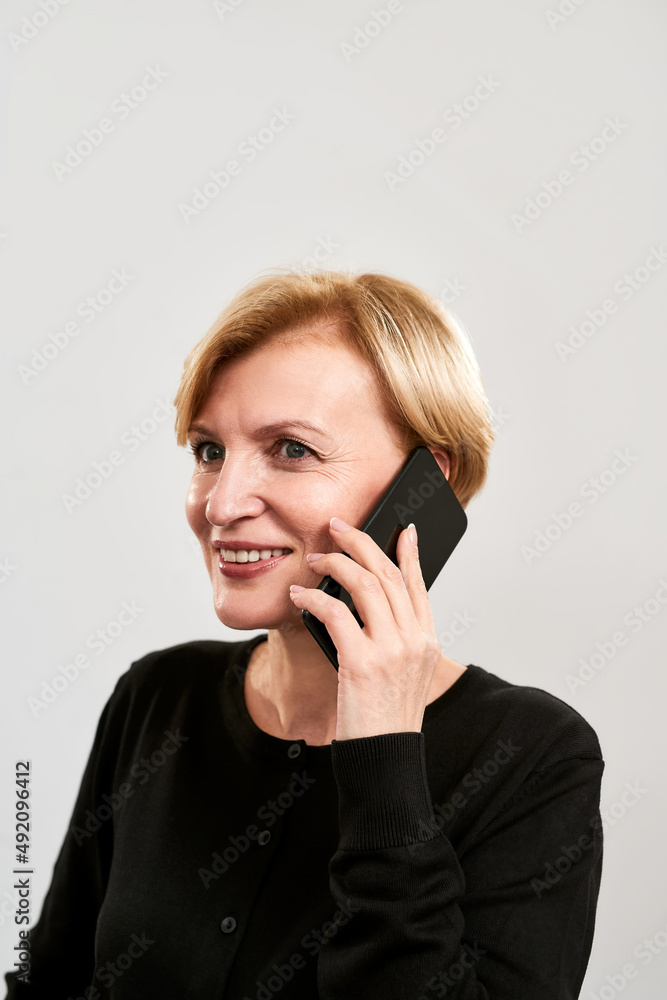 Smiling mature woman talking on mobile phone Smiling mature woman talking on mobile phone