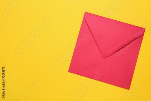 Red envelope on yellow background, top view. Space for text