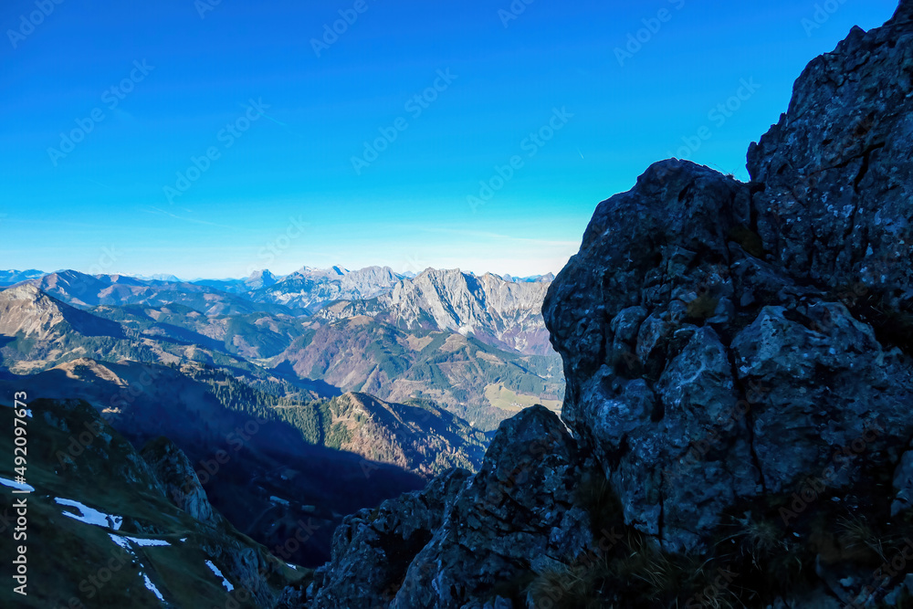 Obraz premium Massive cliff in the shadows of mount Eisenerzer Reichenstein in Styria, Austria, Europe. Austrian Alps. Mountain ridges of the Ennstaler Alps. Kaiserschild in the distance. Hiking trail, Wanderlust