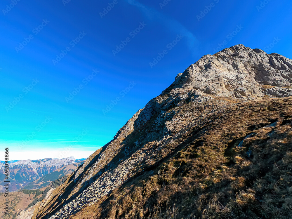 A massive cliff of mount Eisenerzer Reichenstein in Styria, Austria, Europe. Austrian Alps. Bare mountain ridges with view on the Ennstal Valley. Hiking trail, Wanderlust. Sunny day with blue sky