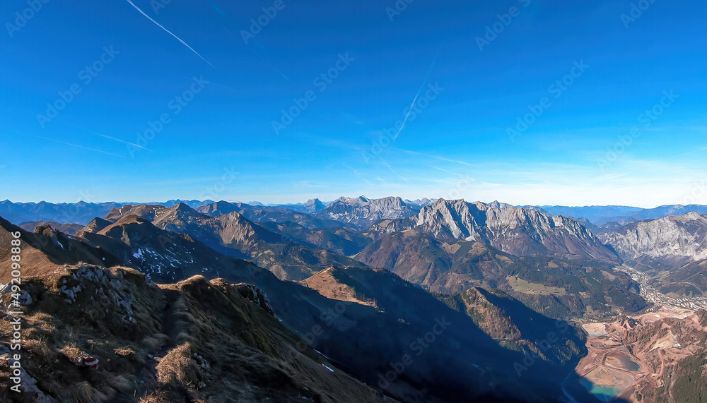 Panoramic view from mount Eisenerzer Reichenstein in Styria, Austria, Europe. Austrian Alps. View on the village Eisenerz and lakes in the Ennstal valley. Hiking trail, Wanderlust. Sunny day in autumn